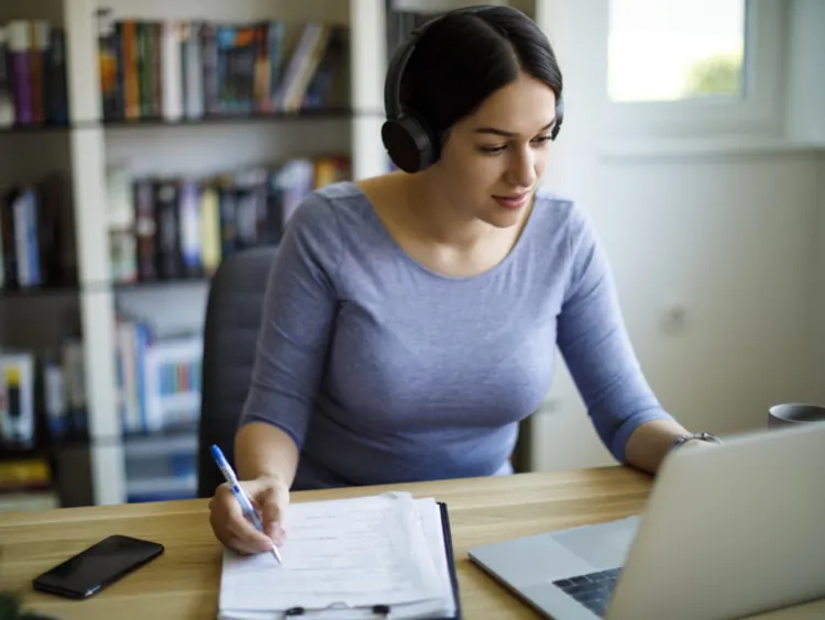 Person Translating A Book, With Dictionaries And Online Resources On Their Desk