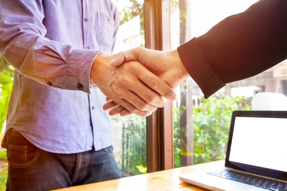 Two People Shaking Hands, Symbolizing A Strong And Positive Client Relationship Built On Trust And Effective Communication, Even In The Face Of Book Printing Errors.